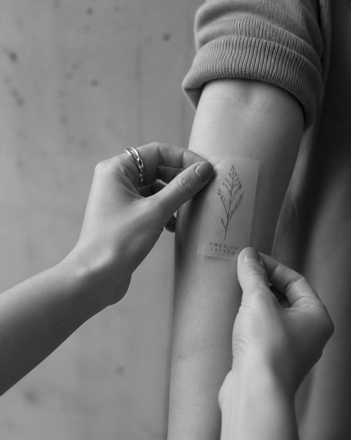 Applying a semi-permanent tattoo sheet to the forearm